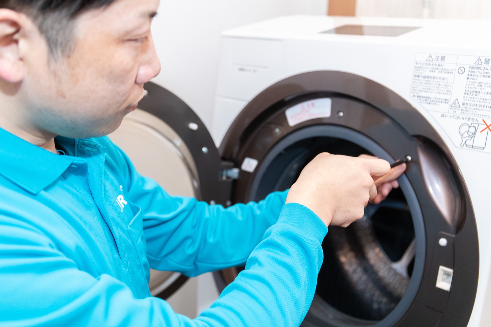 WashManのスタッフがドラム式洗濯機の状態を確認している様子